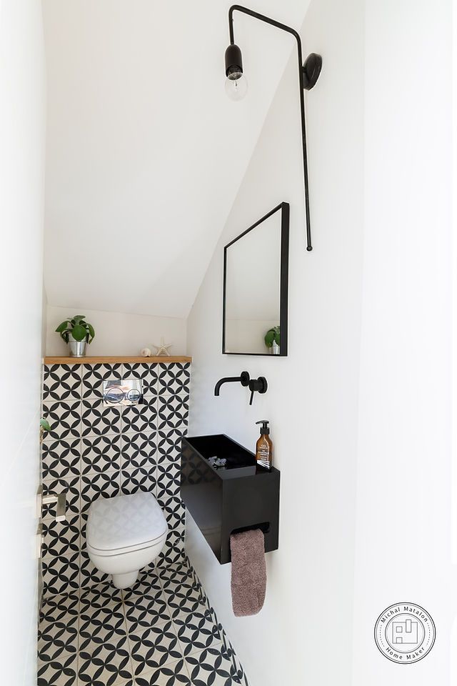 a bathroom with black and white tiles on the walls