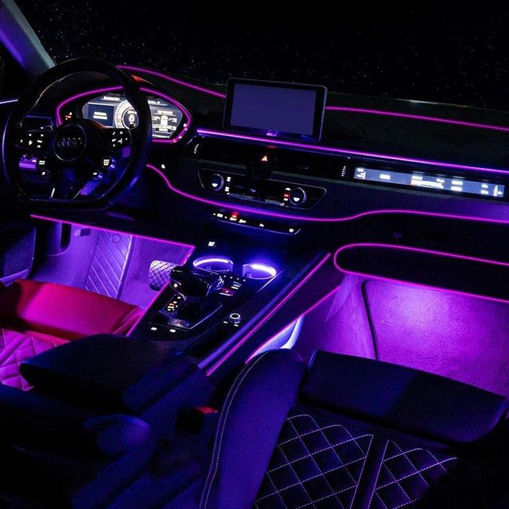 the interior of a car is lit up with purple lighting