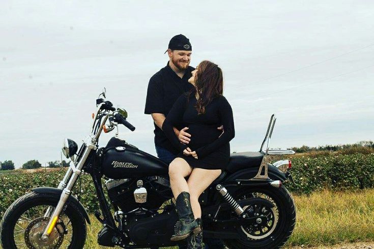 a man and woman are sitting on a motorcycle