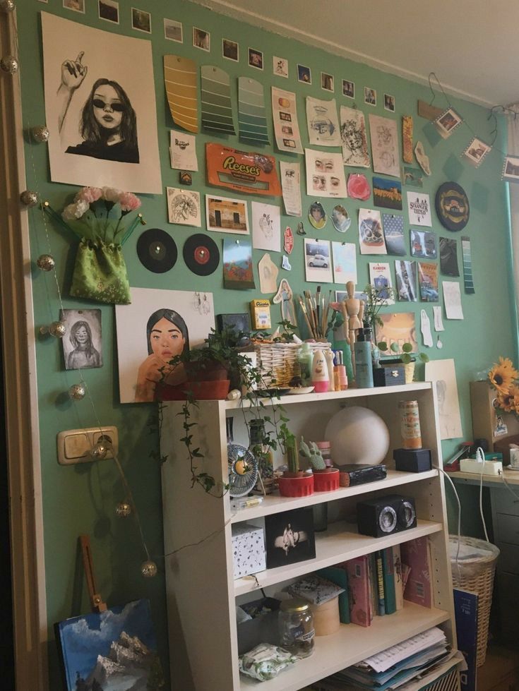 there is a book shelf with many pictures on the wall behind it and plants in vases