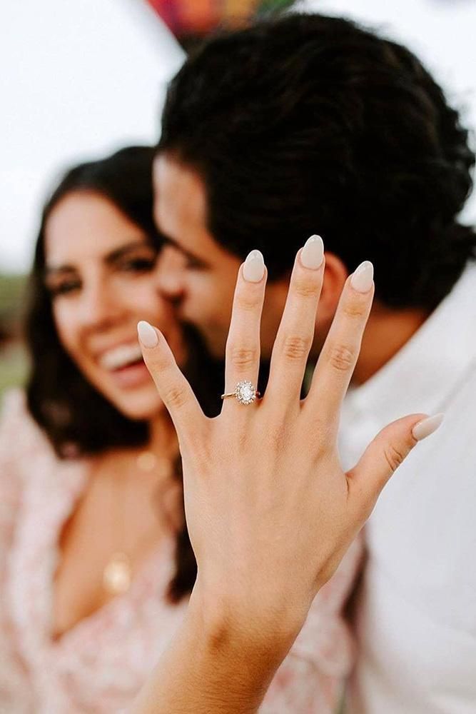 a man and woman holding up their wedding rings