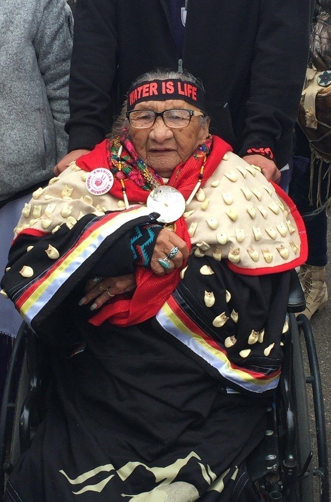 an old woman in a wheel chair holding something