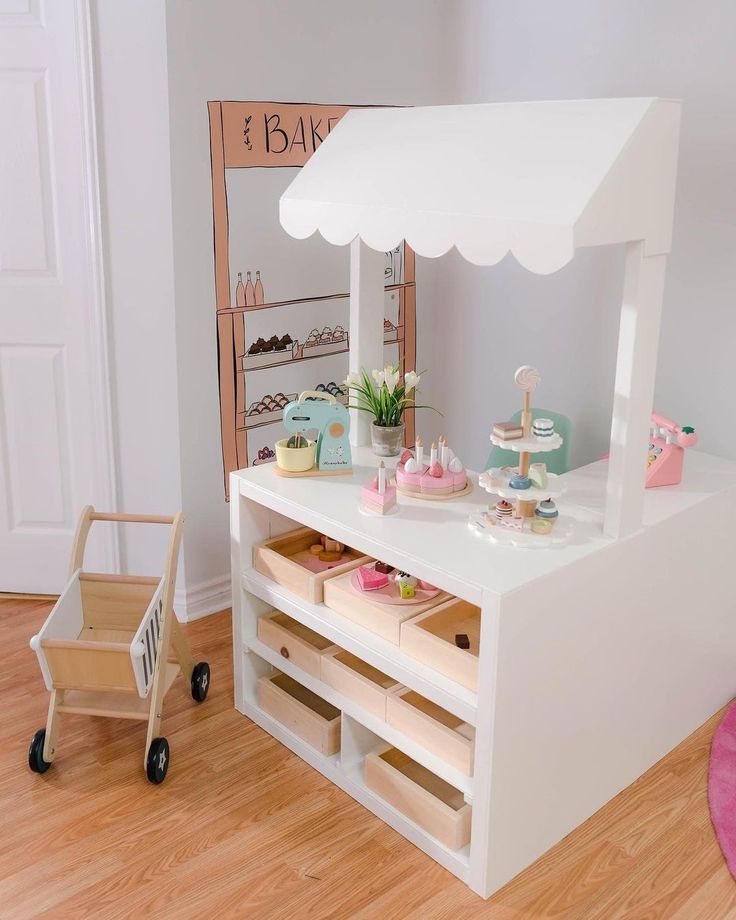 a toy food cart with cupcakes on it in a child's playroom