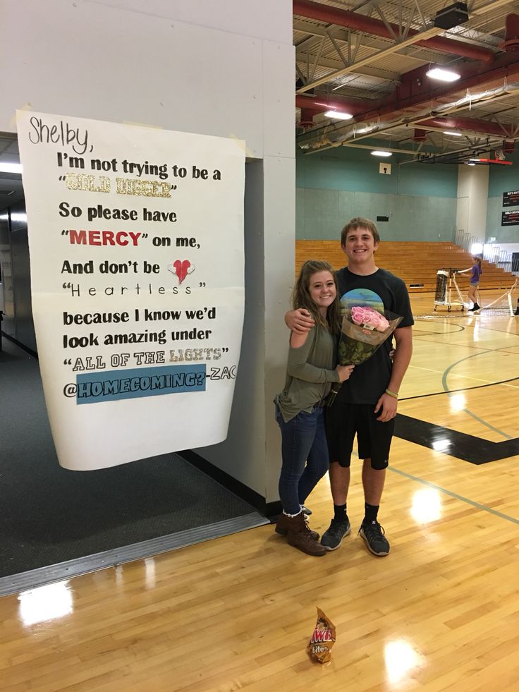 two people standing next to each other in front of a sign that says i'm not trying to be a hero