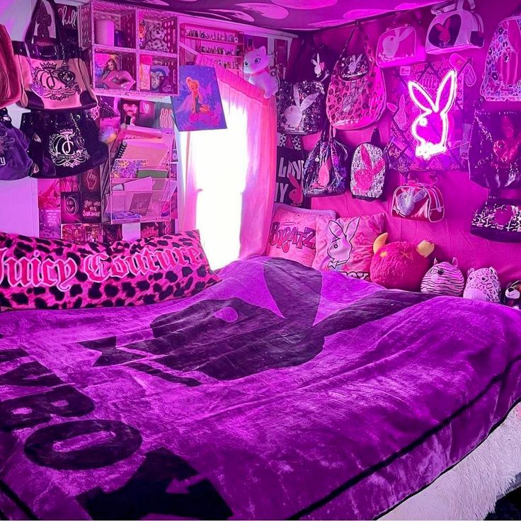 a bed with purple comforter and pillows in a room that is decorated with pink wallpaper