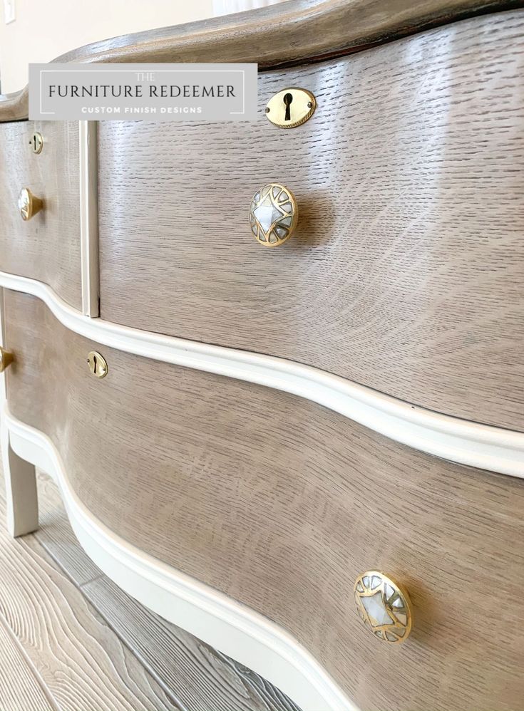 a white dresser with gold handles and knobs