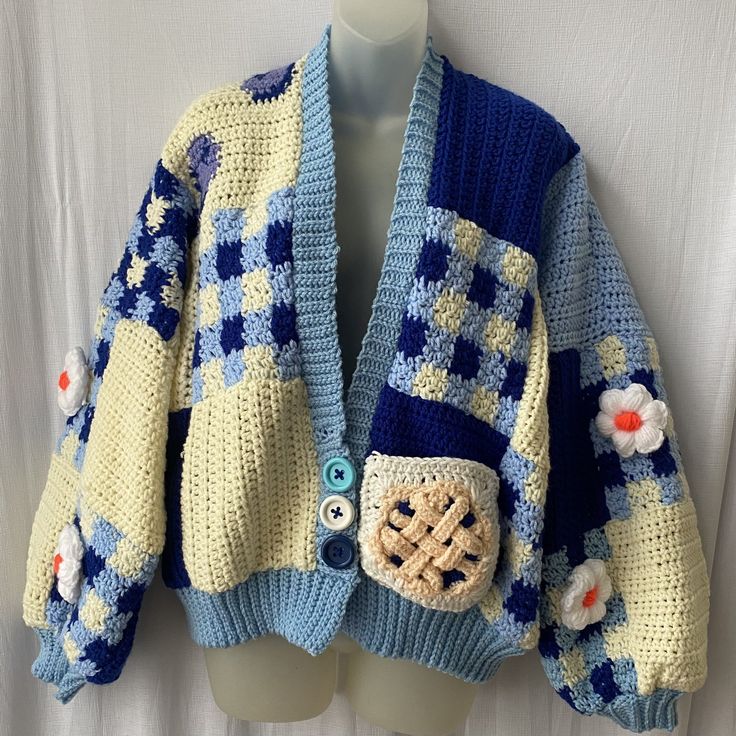 a blue and yellow knitted sweater with flowers on it