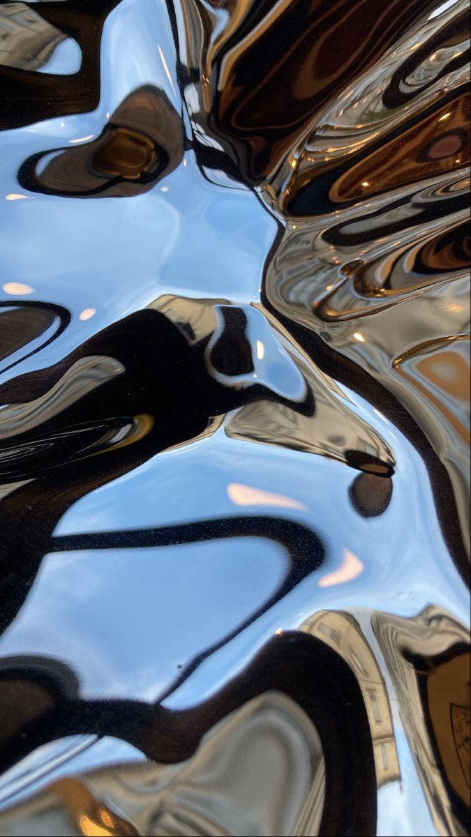 an abstract image of black and white paint on the surface, as well as gold