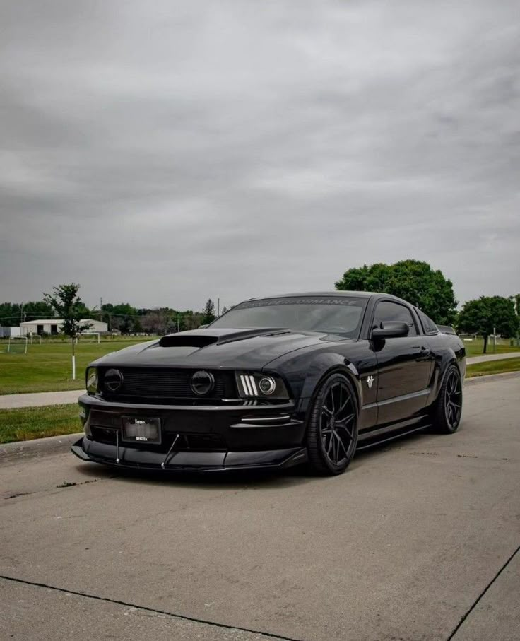 a black mustang is parked on the street