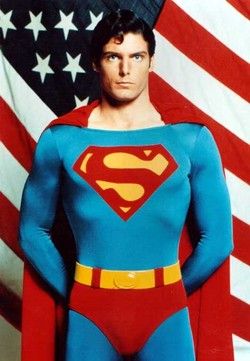 a man dressed as superman standing in front of an american flag