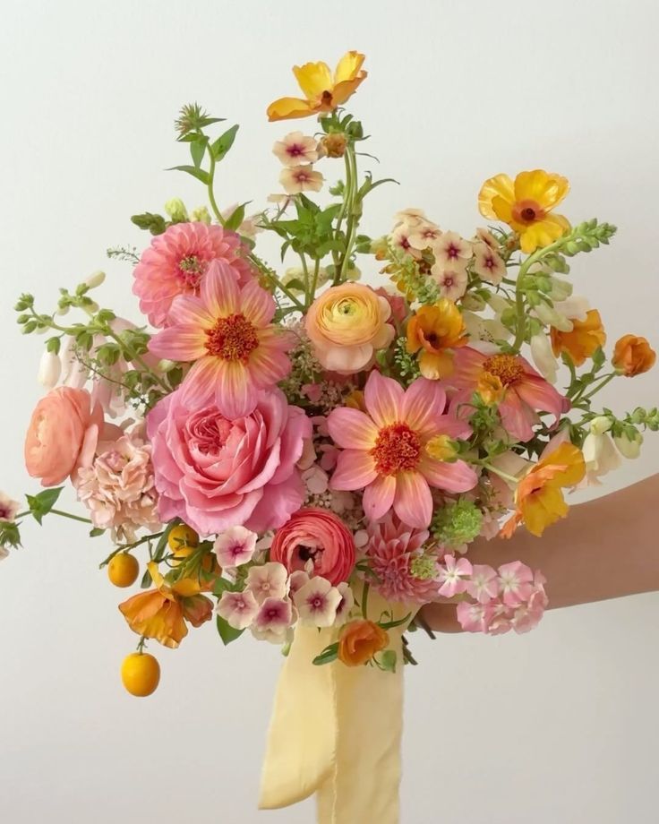 a vase filled with lots of different colored flowers