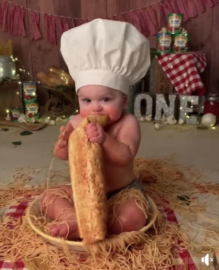 a baby in a chef's hat is eating spaghetti