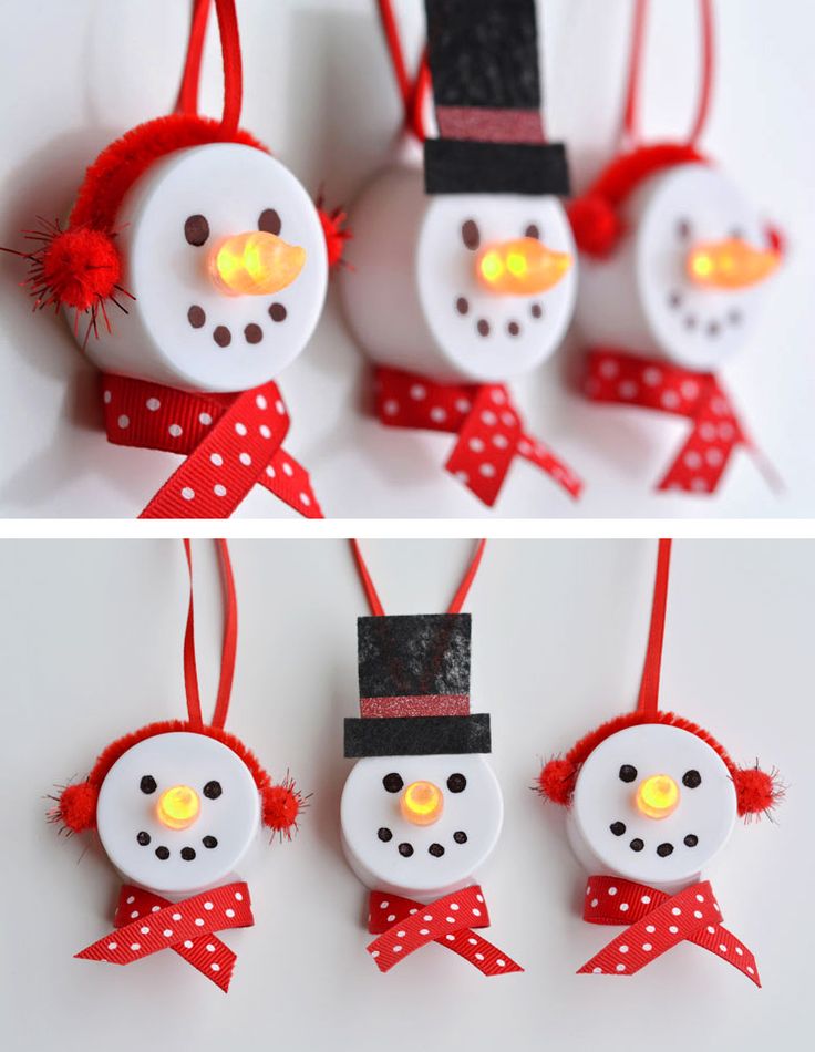 three snowmen are hanging from red ribbon