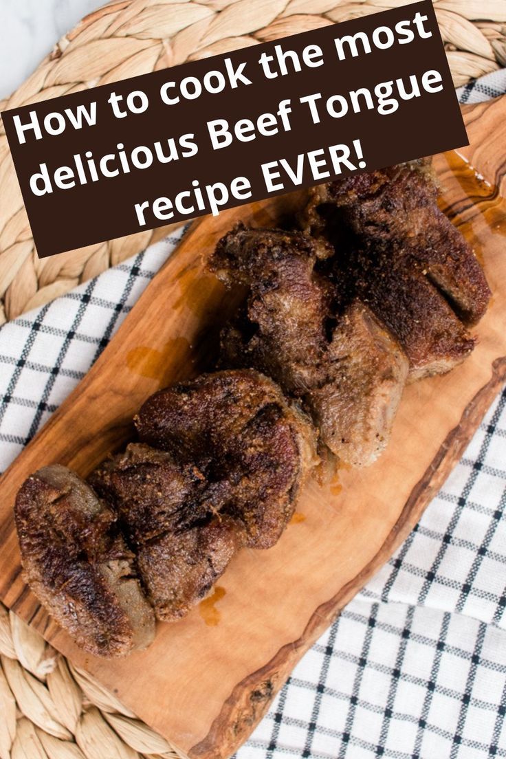 a wooden cutting board topped with meat on top of a table