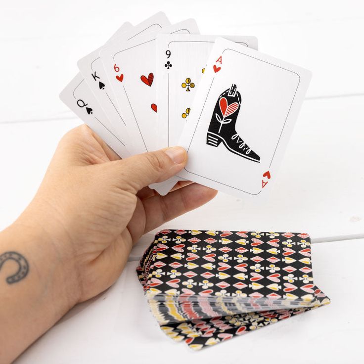 a person holding four playing cards in their hand