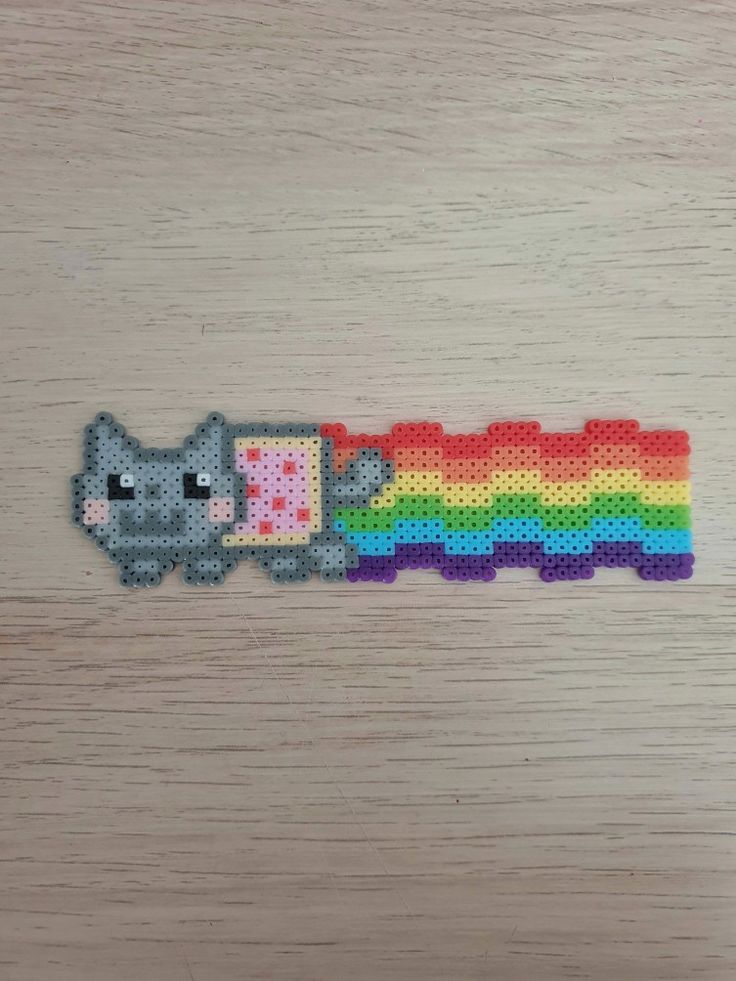 a piece of plastic bead with a cat on it and a rainbow in the background