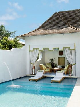 an outdoor pool with lounge chairs next to it