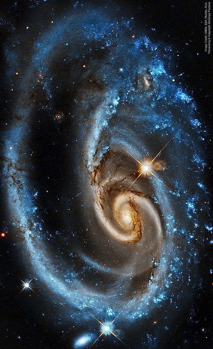 an image of two spirals in the sky, with stars around them and one is blue