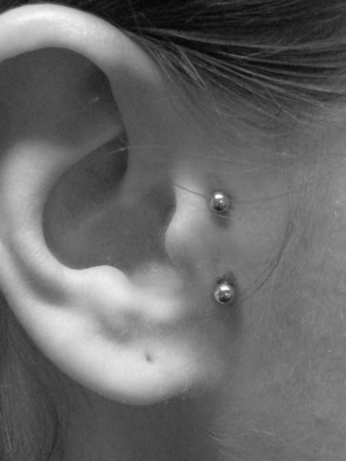 an ear is shown with three piercings on it