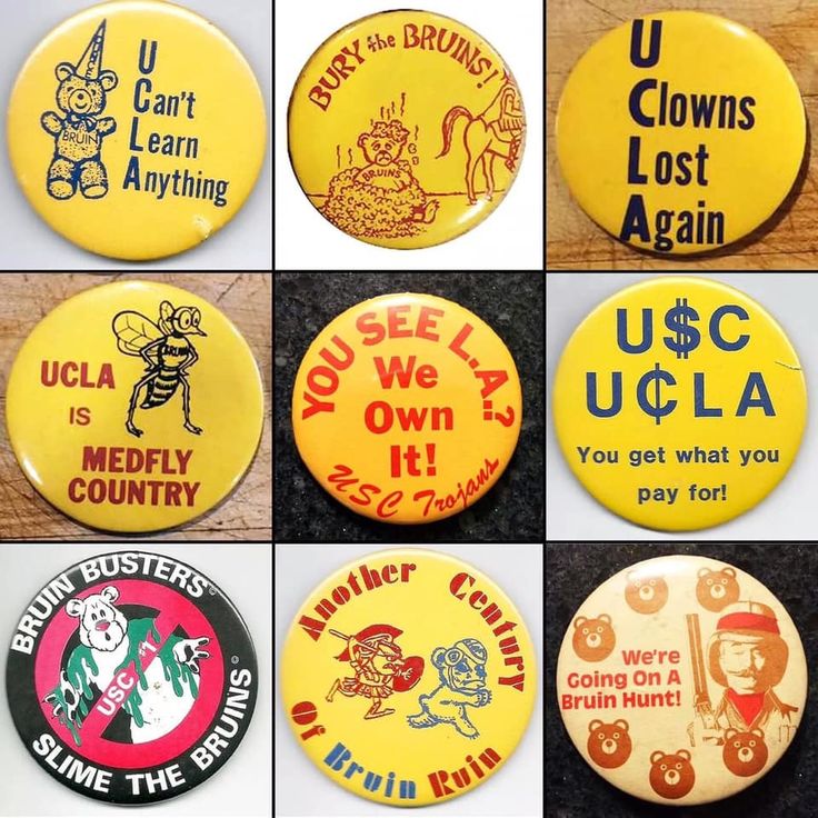 many different buttons that are on a table together, including one with an image of clowns and other sayings