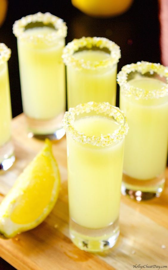 several glasses filled with lemonade sit on a cutting board