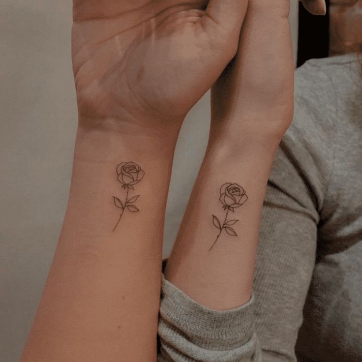 two women with matching tattoos on their arms