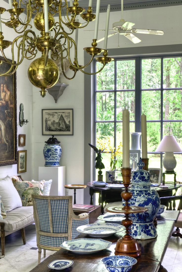 a dining room table with blue and white china on it's centerpieces