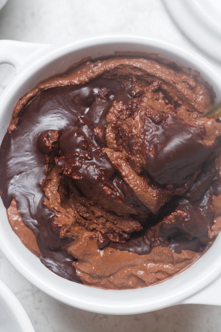 a white bowl filled with chocolate pudding on top of a table