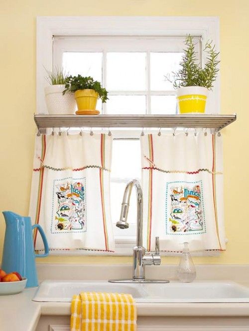 a kitchen sink under a window with potted plants on the windowsill and yellow walls