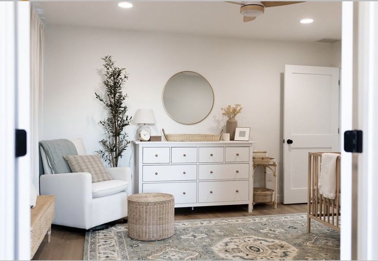 a baby's room with white furniture and neutral decor, including a crib