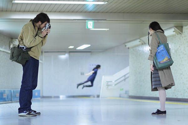 two people standing in an empty room with one holding a camera and the other looking at something