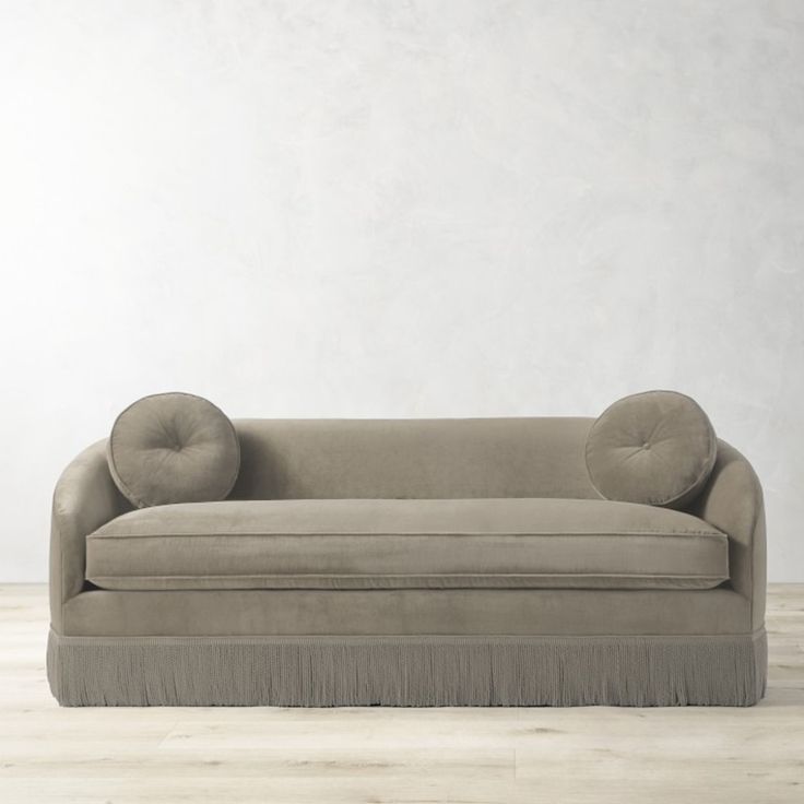 a couch sitting on top of a hard wood floor next to a white wall and wooden floor