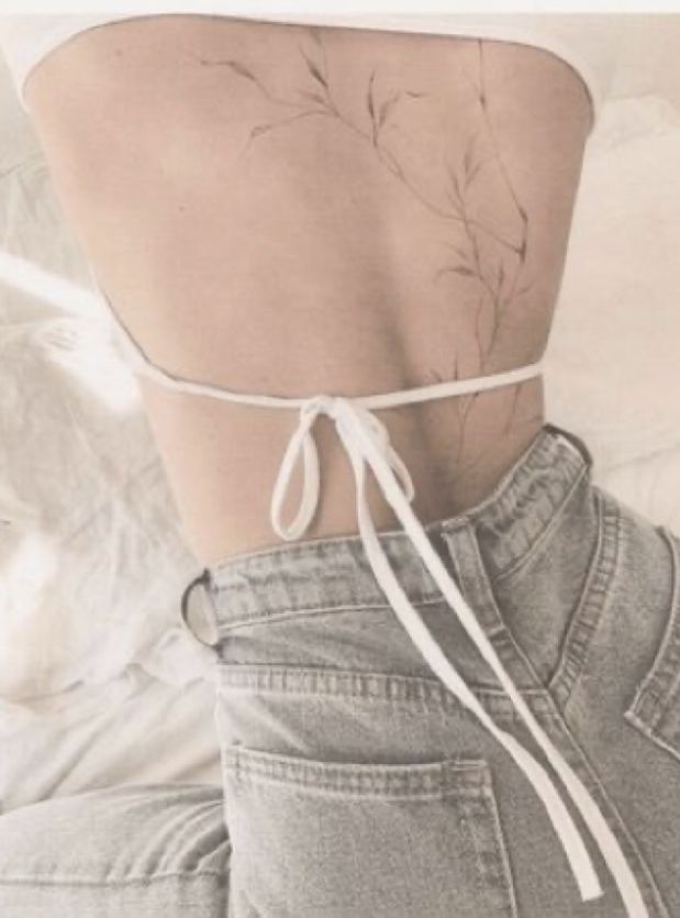 the back of a woman's body with a tattoo on it