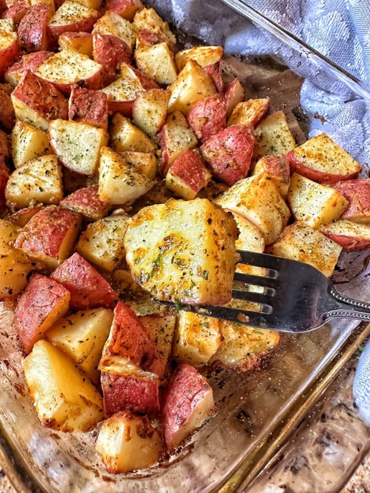 a glass casserole dish filled with potatoes and meat, ready to be eaten