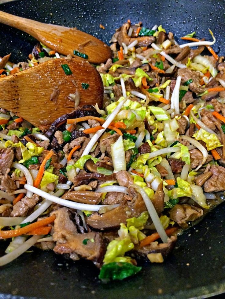 a wok filled with stir fry vegetables and meat