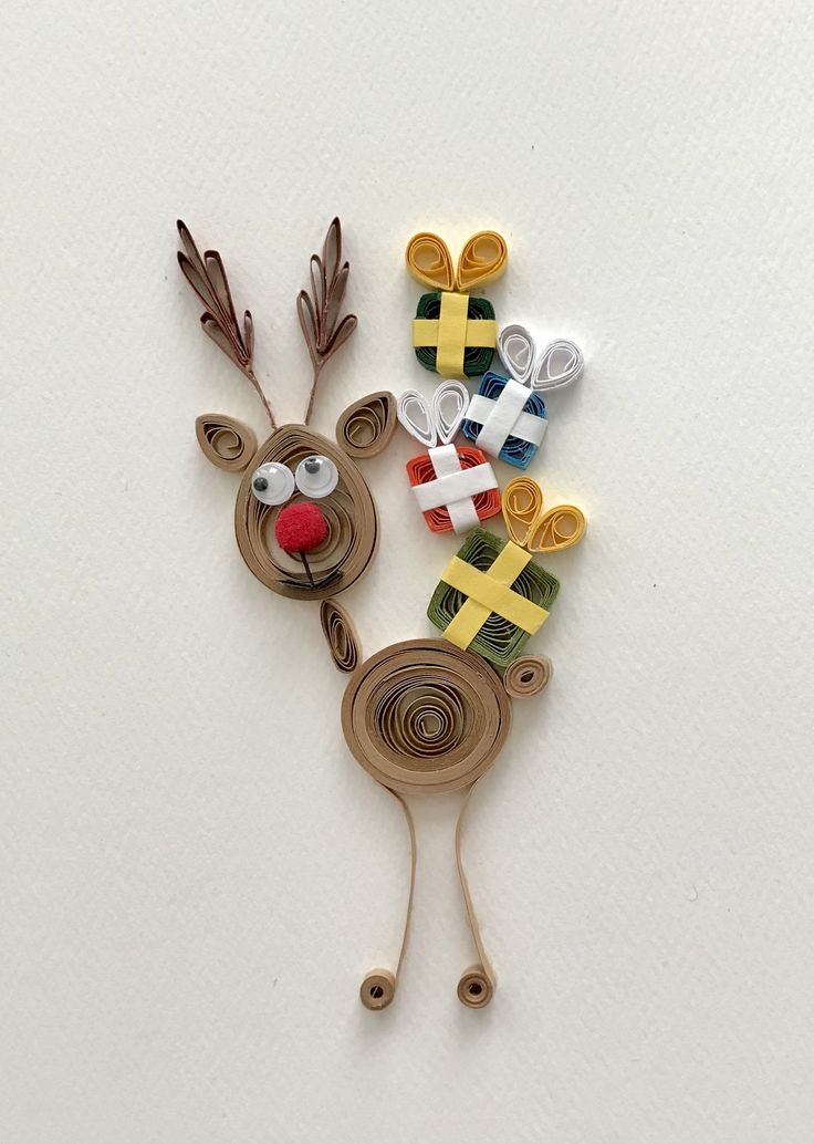 a reindeer made out of paper with scissors and other crafting supplies on it's side