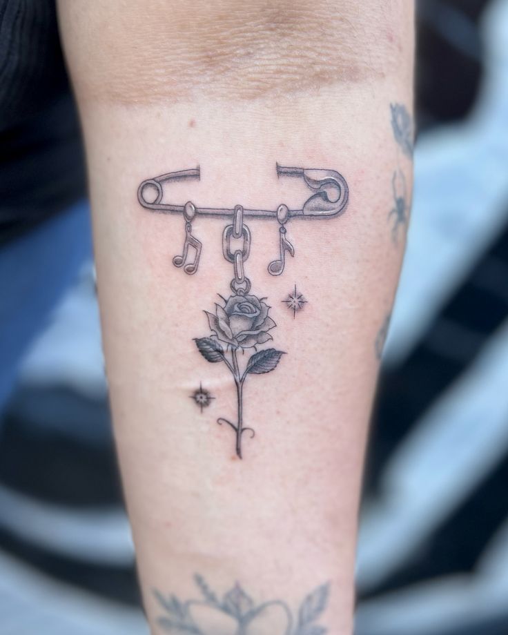 a person with a tattoo on their arm holding a wrench and rose in the center