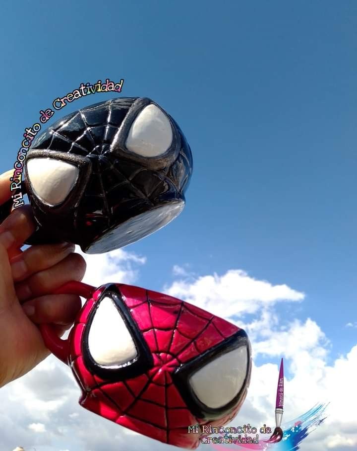 someone is holding up a spider man mask