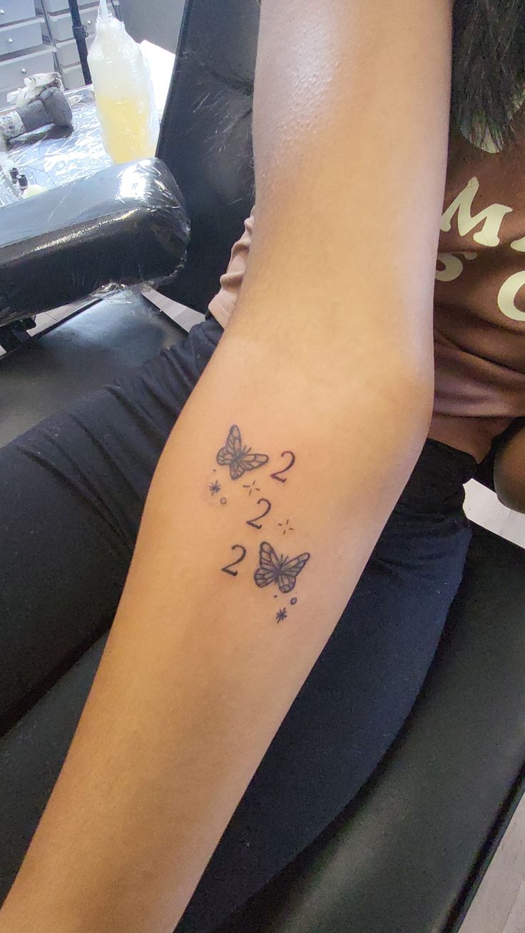 a woman's arm with a butterfly tattoo on the left side of her leg