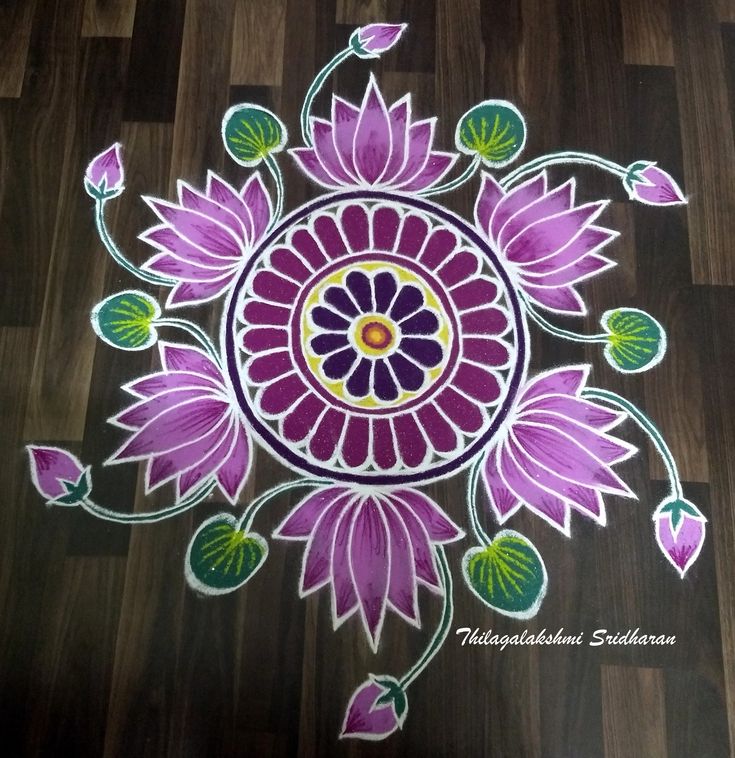 an artistically designed rangolite design with flowers on wood floor for diwaling