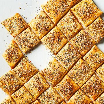 several square pieces of bread with sesame seeds on them and sprinkled with seasoning