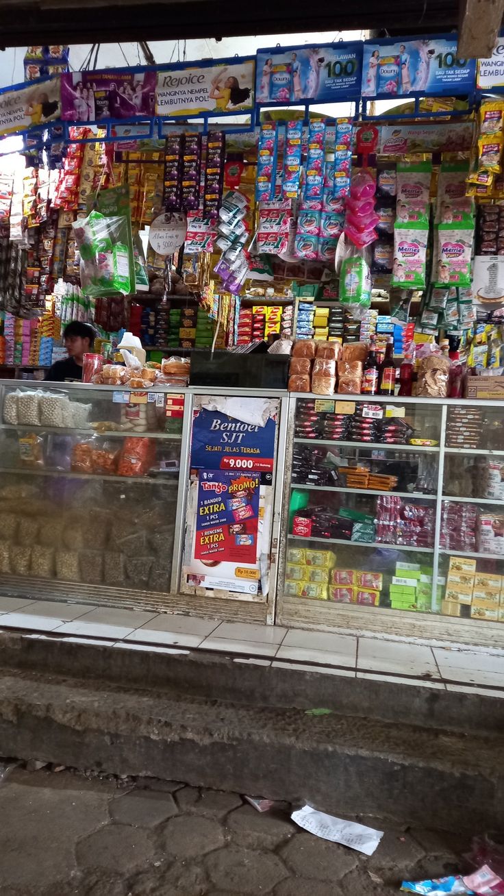 a store front with lots of food on display and signs in the window for sale