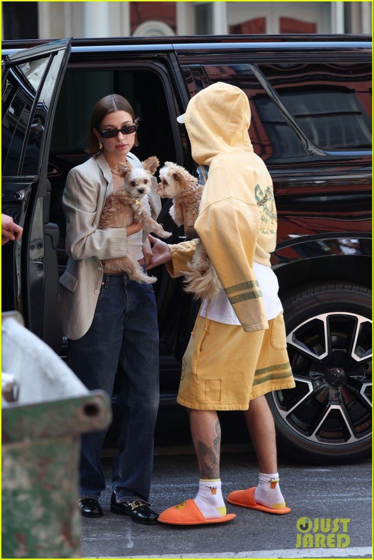 the couple are getting their dog out of the car and ready to go for a walk