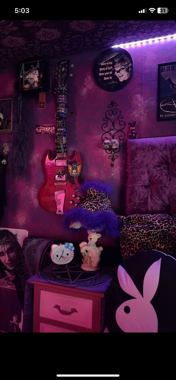 a room with purple walls and pink furniture in the corner is lit up by neon lights