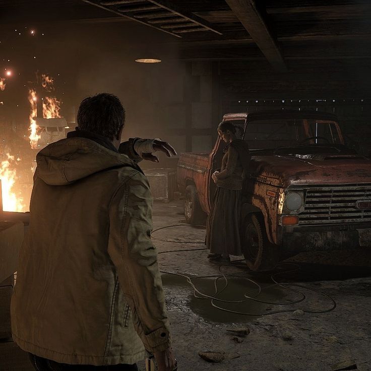 a man standing in front of a truck with flames coming out of the back ground