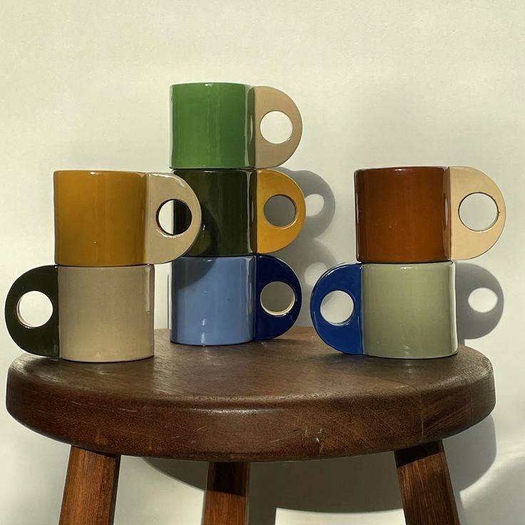 several different colored cups sitting on top of a wooden table