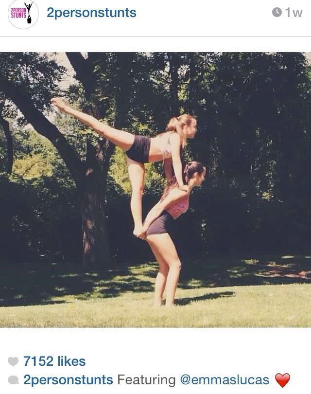 two people are playing with each other in the grass and one person is doing a handstand