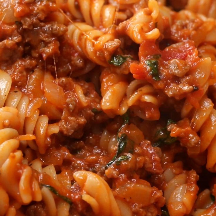 pasta with meat sauce and spinach leaves on top