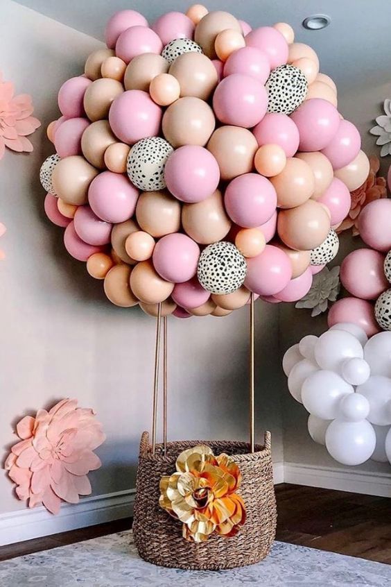 a balloon filled with lots of balloons on top of a table next to a basket