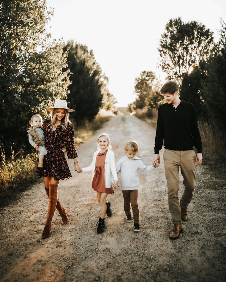 a family walking down a dirt road holding hands